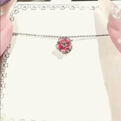 Demonstration of the Auranudge Blossom Shift Kinetic Necklace transforming from a peach blossom to cascading hearts.