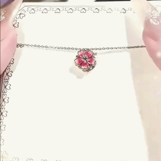 Demonstration of the Auranudge Blossom Shift Kinetic Necklace transforming from a peach blossom to cascading hearts.
